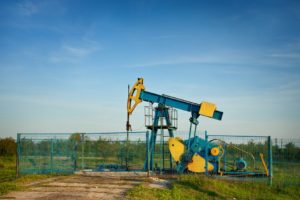 Industrial landscape with an oil pump at sunset